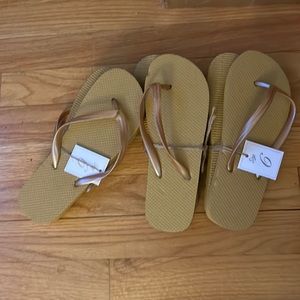 3 pair of size 6 flip flops in a rich golden tannish color.  Brand new